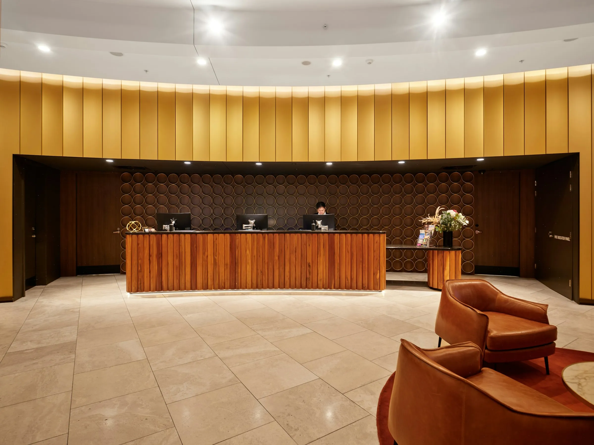 A hotel reception desk with a staff member at a computer